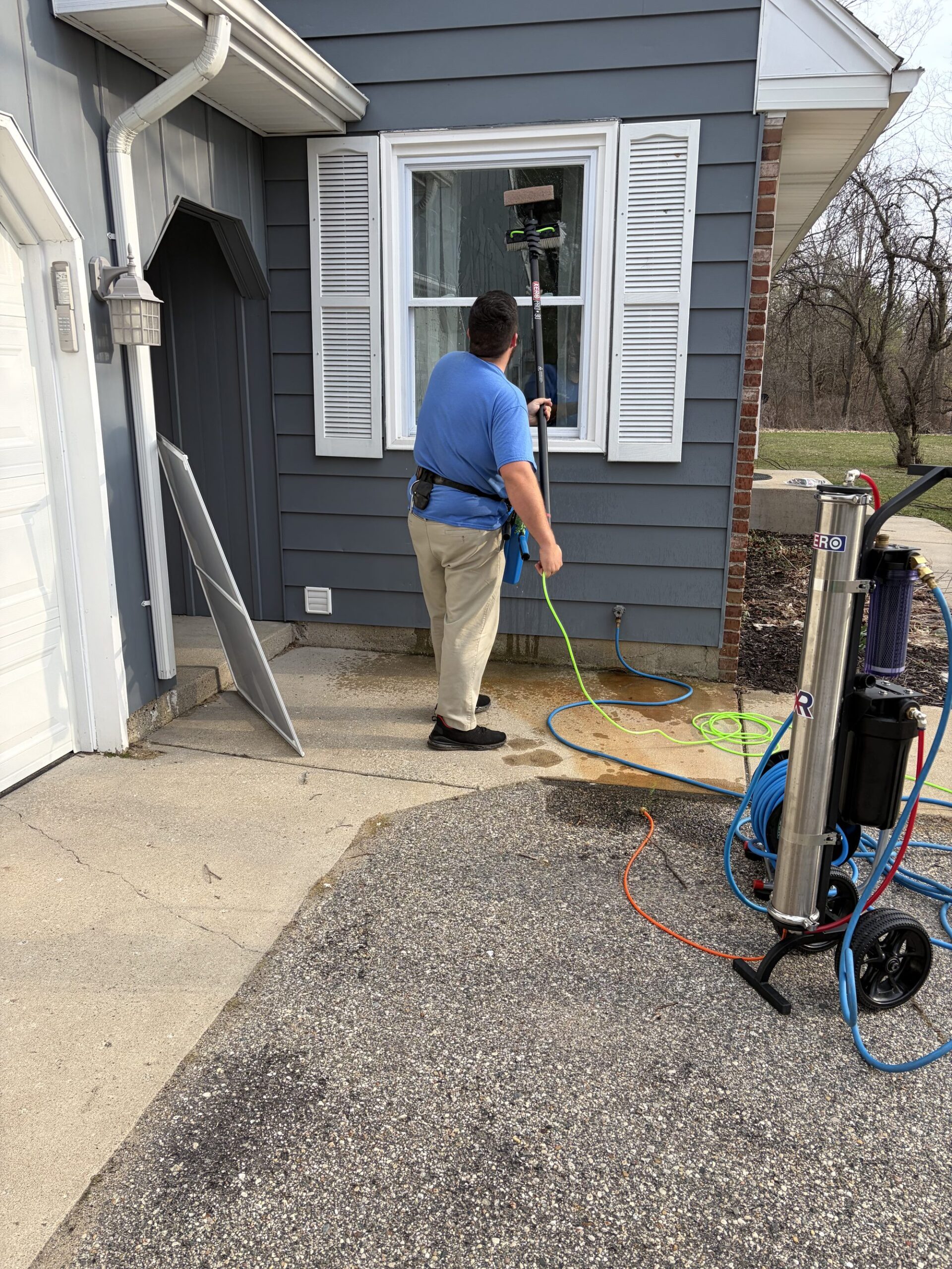 Moonwalker Window Cleaning crew cleaning windows on a Caledonia MI home