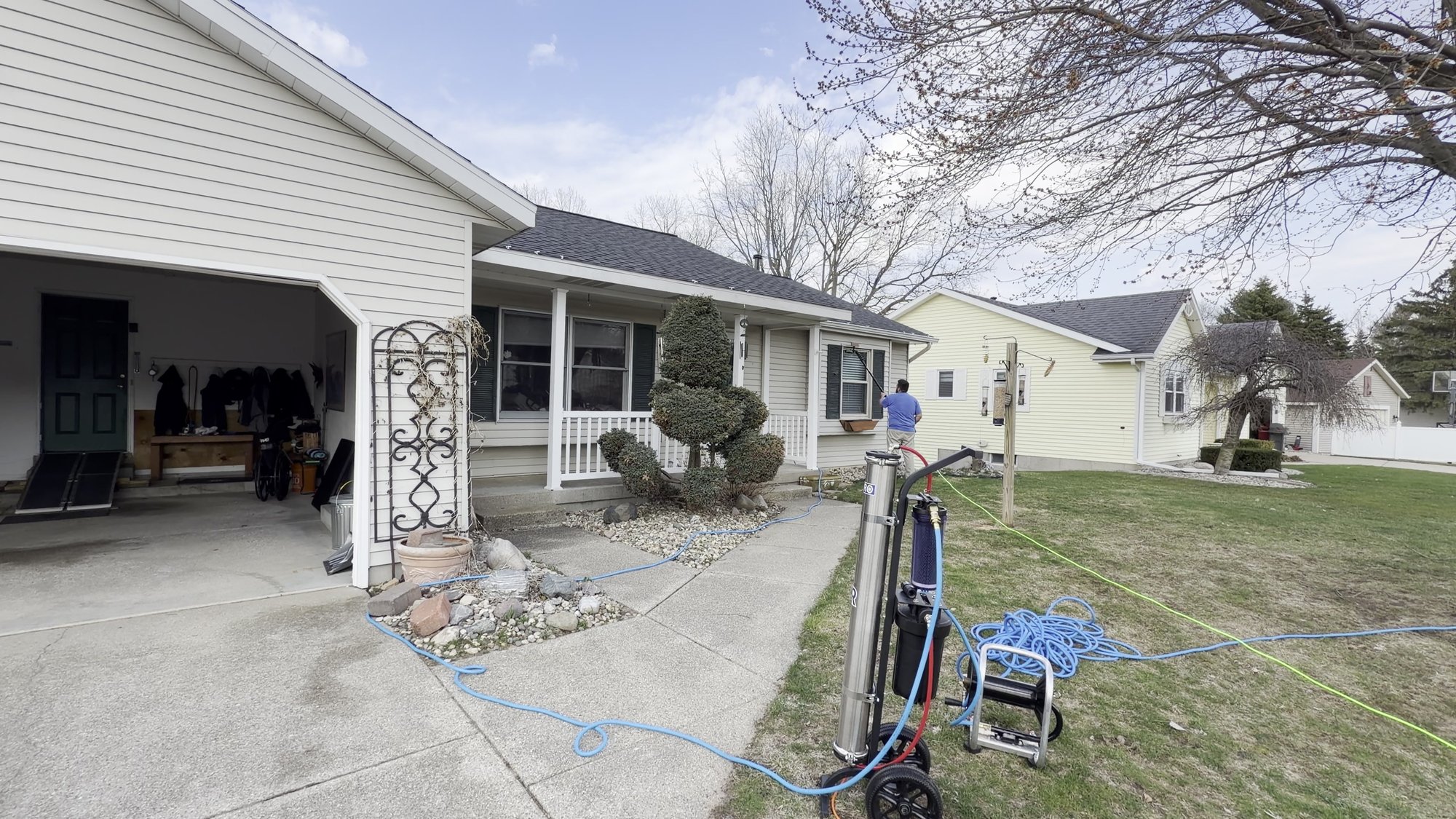Moonwalker Window Cleaning crew cleaning windows on a home in Jenison Michigan with water fed pole